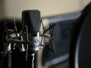 Condenser microphone with shock mount in front of a sound amplifier.