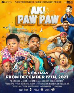 Colorful movie poster for "Aki and Paw Paw," showcasing a collage of actors in comedic poses against a city skyline with a helicopter overhead. Crafted with precision at the renowned dubbing studio, text reveals the release date: December 17th, 2021.